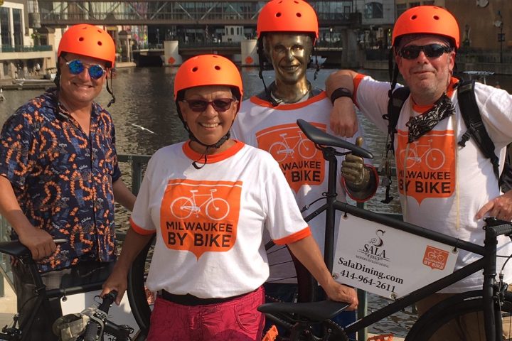 a group of people riding on the back of a bicycle